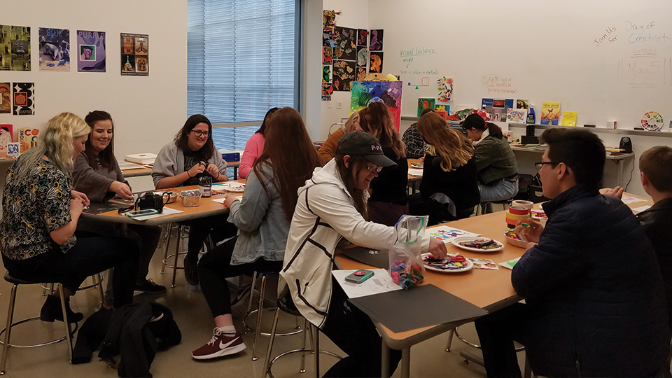 an art classroom in the Nerman full of students working on projects