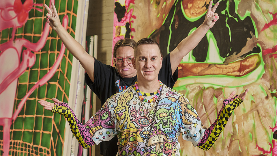 Katherine Bernhardt and Jeremy Scott posing in front of a painting