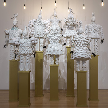 eight white statutes on pillars on display at the Nerman Museum